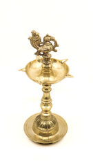 a vintage indian samai or vilakku, an oil lamp with a peacock bird emblem used to light fire and pray to god during religious events and rituals isolated