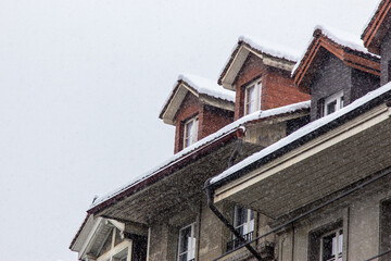 snow fall on house roof in switzerland - 673062594