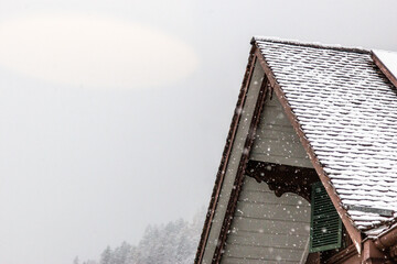 snow fall on house roof in switzerland - 673062723