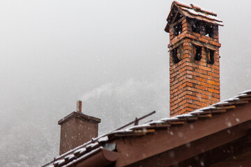 snow fall on house roof in switzerland - 673062732