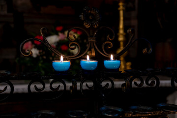 3 bougies bleues dans une église catholique en Europe