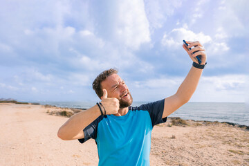 sporty man taking a selfie on the beach