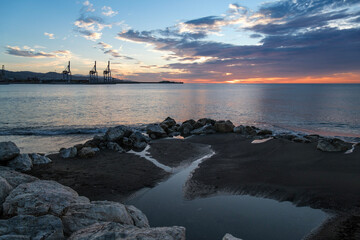 Playa de Huelin, Málaga, vista del puerto al fondo, amanecer, primeros rayos de sol, mar en calma