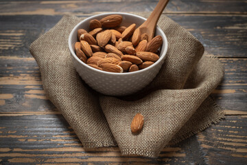 Almonds in a bowl on a yellow background.