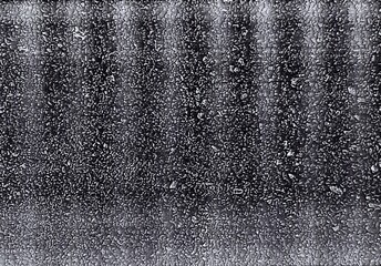 Roasted and ground coffee beans until they are fine, combined with a large quantity of black and brown fiber husks, creating a complex background with small, intricate black and white patterns.  © SURACHAI