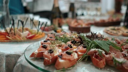 Catering service on banquet table with canape snacks in restaurant or hotel. Decorated food set on birthday, wedding celebration or business conference event venue.