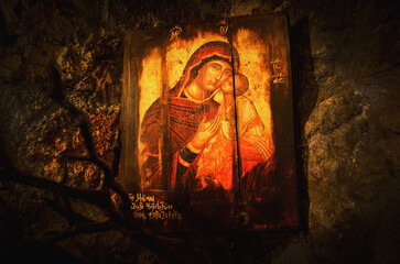 Religious orthodox wooden icon on rocks. Found on an old very small church inside a cave