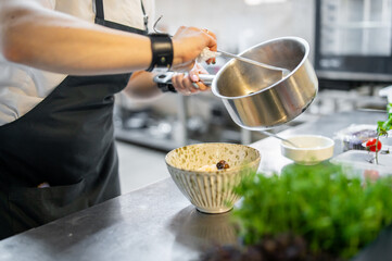 woman chef cooking seafood soup on restaurant kitchen