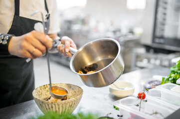 woman chef cooking seafood soup on restaurant kitchen - obrazy, fototapety, plakaty