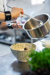 woman chef cooking seafood soup on restaurant kitchen