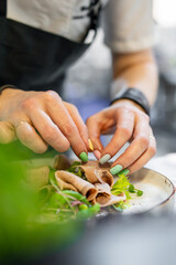 Chef cooking Beef tongue salad with fresh vegetables on restaurant kitchen