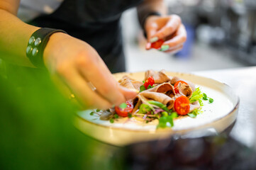 Chef cooking Beef tongue salad with fresh vegetables on restaurant kitchen