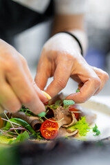 Chef cooking Beef tongue salad with fresh vegetables on restaurant kitchen