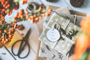 Christmas gift box stack on wooden table, let it snow