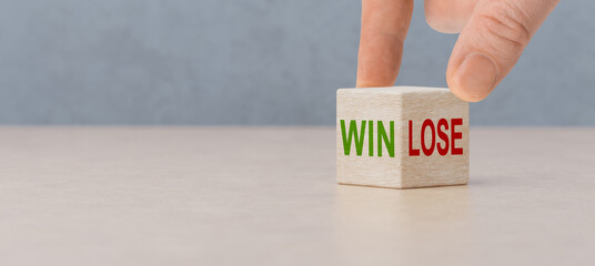 Win or lose, business concept. Businessman hand turns wooden cubes and changes word Lose to Win....