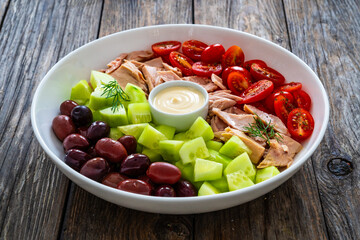 Tuna greek salad on wooden background