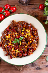 Hot and spicy fresh made mexican dish chili con carne soup with meat, vegetables and red beans on table. Goulash