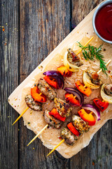 Meat skewers - grilled meat with vegetables on wooden background
