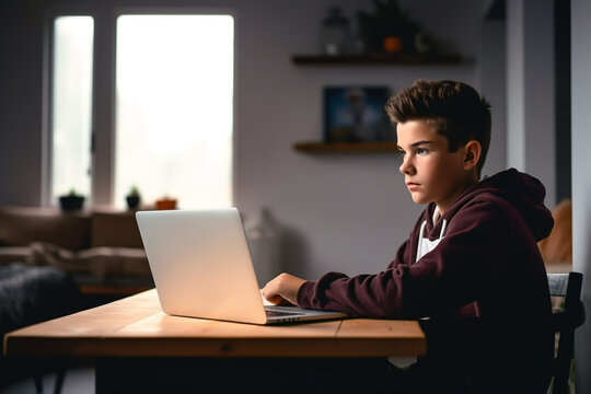 Portrait of a Boy Sitting at the Table Using the Laptop Computer