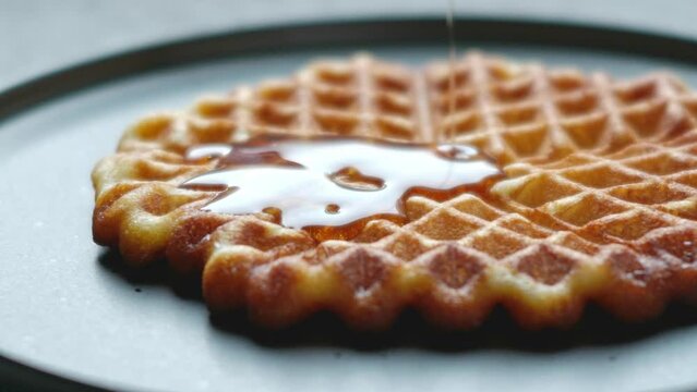 Frisch gebackene Waffeln in Herzform mit Ahornsirup.