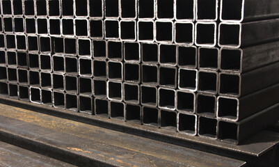 stack​ of square​ metal tubes​ profile or pipes for construction supplies and welding works....