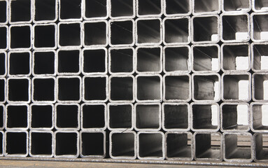 stack​ of square​ metal tubes​ profile or pipes for construction supplies and welding works. Industry background
