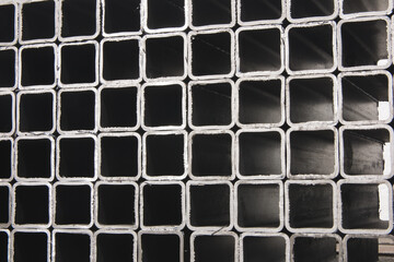 stack​ of square​ metal tubes​ profile or pipes for construction supplies and welding works. Industry background