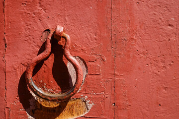 The ancient metal door knob on a red plain wall of the Dutch period colonial building in the port...