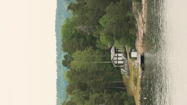 Black Scandic Wooden Houses On Island Coast In Summer Cloudy Day. Vertical Footage Video Hyperlapse. Nordic Architecture. Scandinavian Culture And Nature. Travel Concept To Sweden.