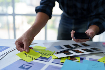 Developer, UI, UX designer, mobile app interface creation process, wireframe On the work desk for mobile app, phone app development plan layout design layout at modern office.
