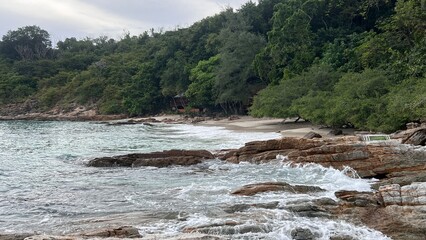 Sea waves hitting rocks on the beach.