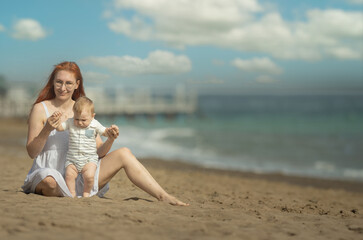 Happy mother and her little son resting on the seaside