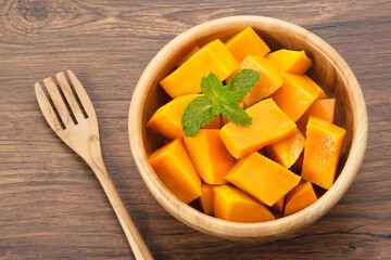 Fresh and ripe mango fruit slice on wooden bowl
