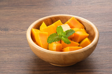 Fresh and ripe mango fruit slice on wooden bowl
