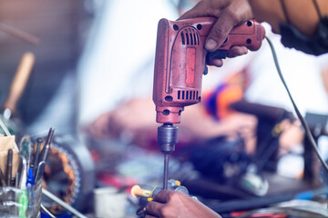 Selective focus to tools and hand of an electric motor repairman. Mechanic is repairing an electric...