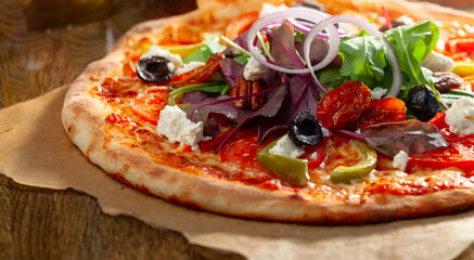 Tasty fresh baked vegetarian pizza with tomatoes, olives, ricotta, and fresh greens.
