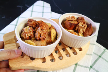 Hand Holding a Breadboard of Freshly Baked Delectable Banana Bread Pudding Bowls	