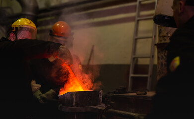 Pouring molten metal into a centrifugal machine in the foundry shop of metallurgical plant