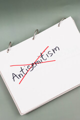 Antisemitism minimalistic concept. Crossed out with red lines Word Antisemitism written on white paper.