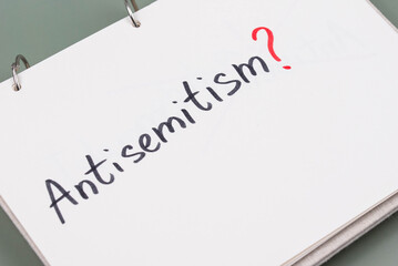 Antisemitism minimalistic concept. Word Antisemitism written on white paper with question mark. 
