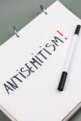 Antisemitism minimalistic concept. Word Antisemitism written on white paper with Exclamation point. 