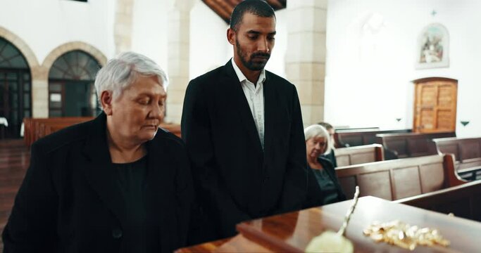 Funeral, coffin and senior woman with flower in church for goodbye, mourning and grief in memorial service. Depression, family and people by casket in chapel for greeting, loss and sad for death