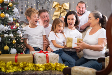 Family with children holding gifts in christmas interior