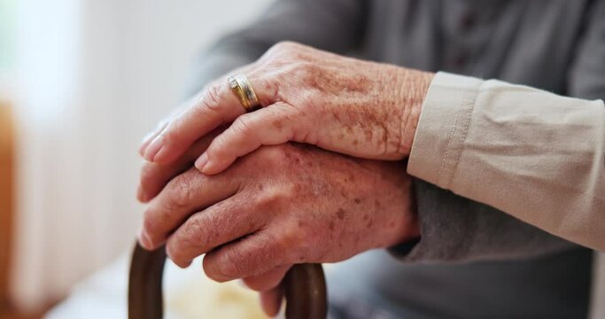 Holding hands, walking stick and a senior couple closeup for love, support or trust in the bedroom of a home together. Empathy, medical or healthcare with an elderly man and woman in their apartment