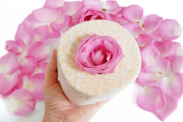 Obraz na płótnie Canvas roll of toilet paper with fresh roses and petals on wршеу background, gentle and soft toilet paper with rose fragrance