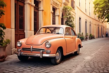 Fotobehang Vintage peachy car parked on a European city street. Retro charm and travel concept. Apricot Crush color trend. Suitable for nostalgic event posters, banners, or wallpapers © dreamdes
