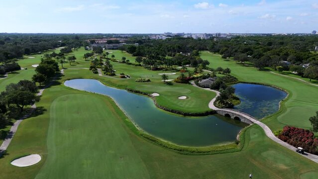 Bird's-eye shot of luxurious golf course revealing diverse range of holes. Players encountering incredible trials, twists and turns