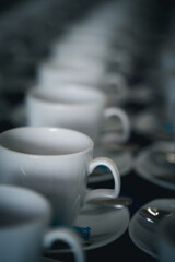 Group of many empty cups with spoons for service coffee or tea in seminar event or meeting room