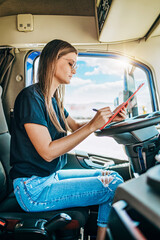 Portrait of beautiful young woman professional truck driver sitting and resting after long drive....