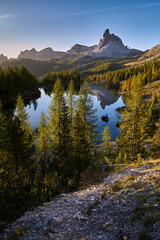Amazing sunrise on Lago di Federa. Autumn landscape in the morning in the Italian Dolomites with a view of the Croda do Lago peak. Vertical view.
